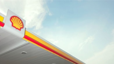 El pecten de Shell en rojo y amarillo hacen contraste con un cielo azulado.