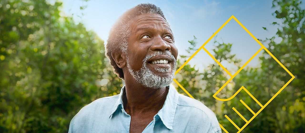 Hombre sonriente con barba delante de unos árboles con un resumen del gráfico de generación de valor para el accionista