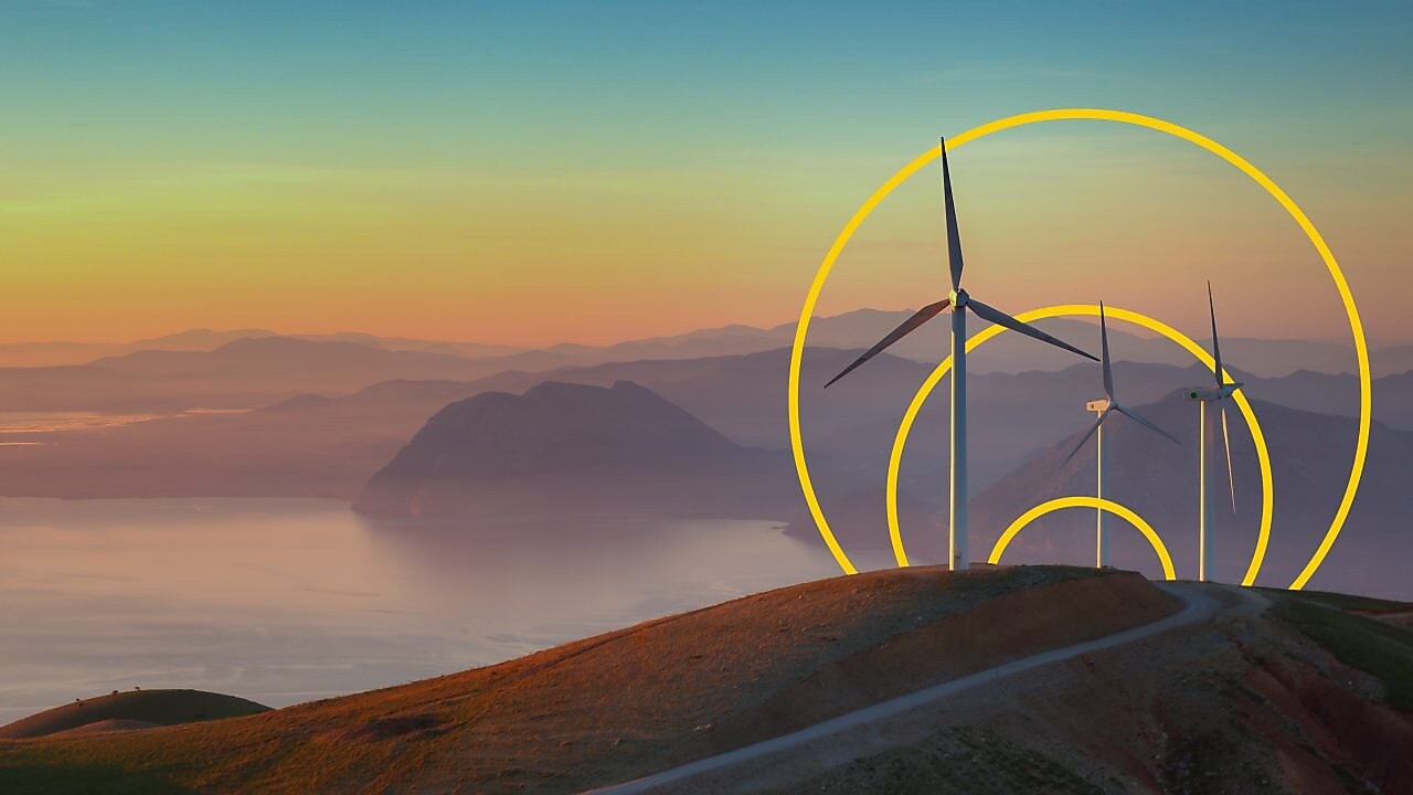 Fotografía de tres turbinas eólicas en una colina con el contorno del gráfico de logro de emisiones netas cero