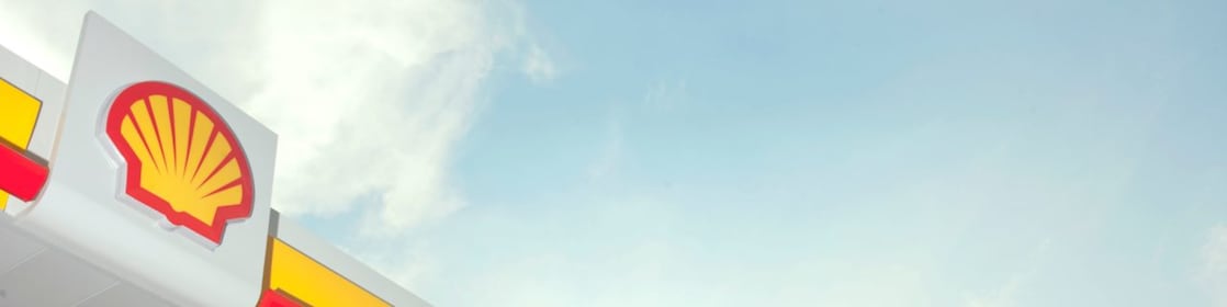El pecten de Shell en rojo y amarillo hacen contraste con un cielo azulado.