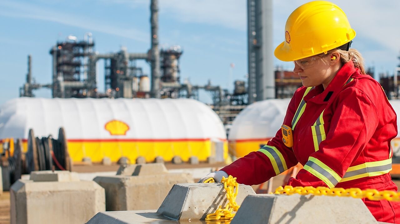 Mujer en uniforme rojo trabajando en refinerías