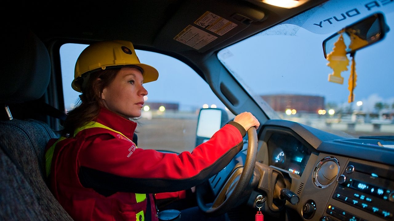 Señora con equipo de seguridad conduciendo un vehículo