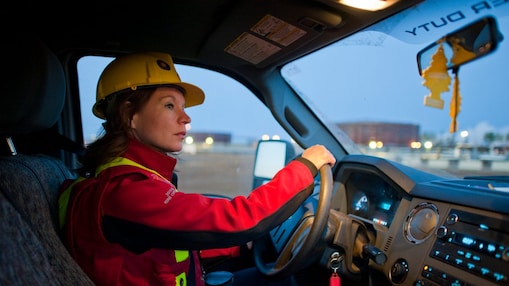 Señora con equipo de seguridad conduciendo un vehículo